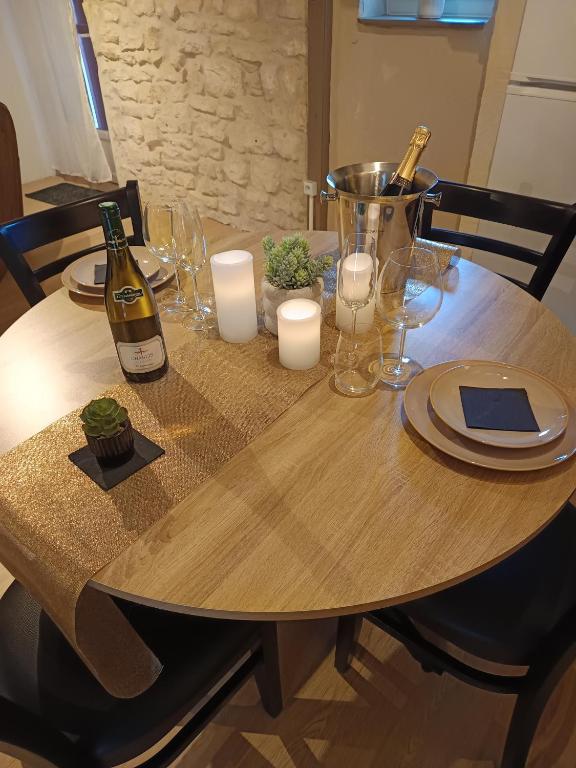Table dressée pour deux, champagne et bougies, devant le mur en pierre de la maison